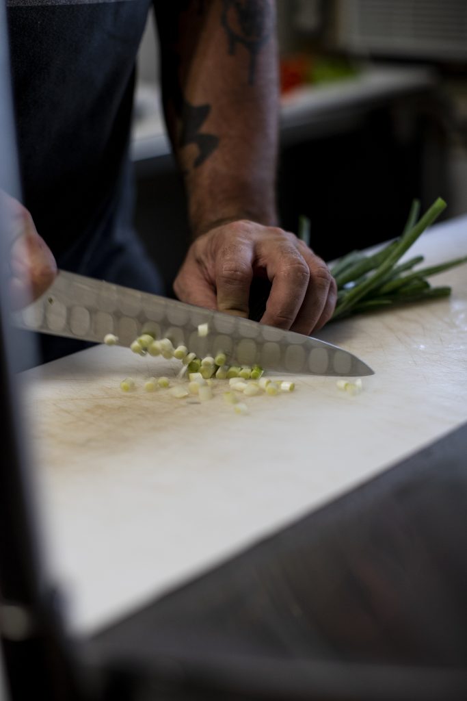 Chef Jessie Steele chopping scallions at Dada in Delray Beach