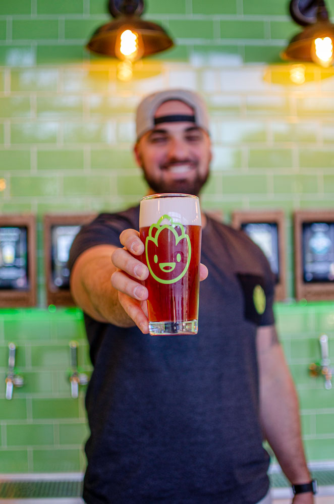 Employee holding a beer inside Hopportunities in Delray Beach