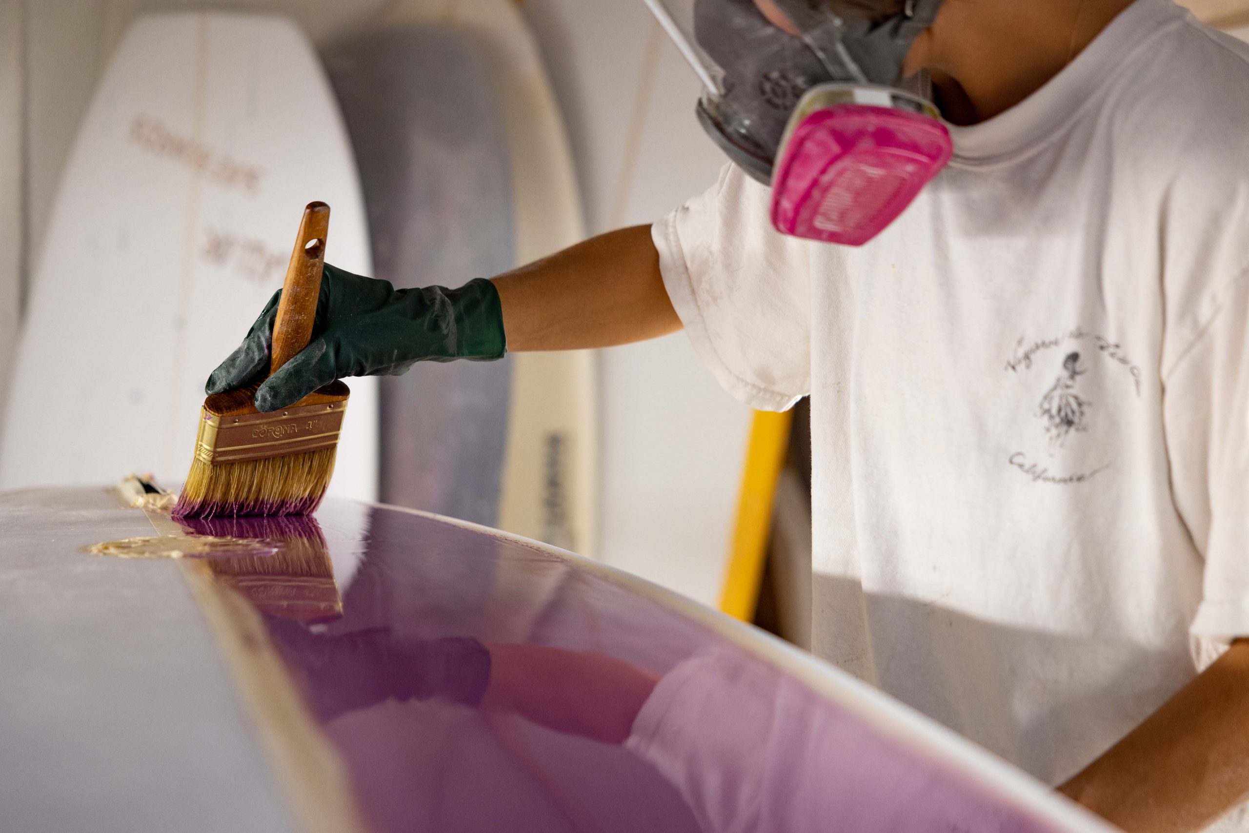 Catherine Girard painting surfboard