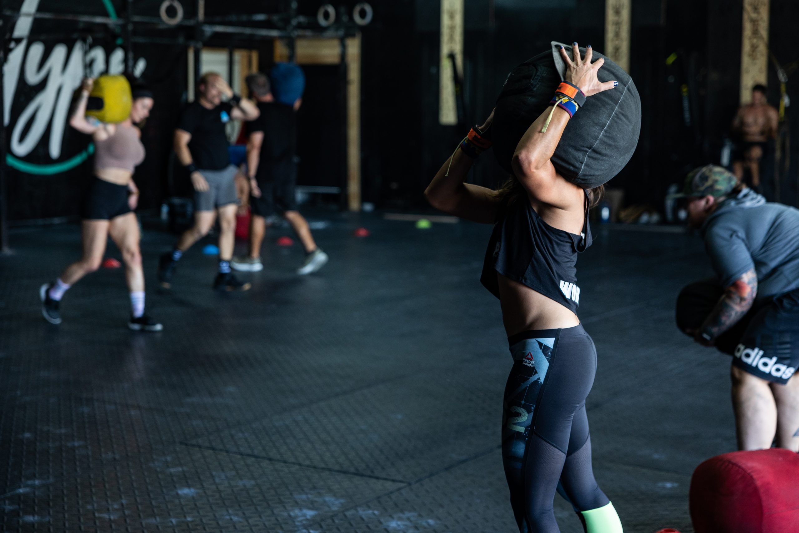 Temperance Training student carries care weight over her shoulder during CrossFit training class