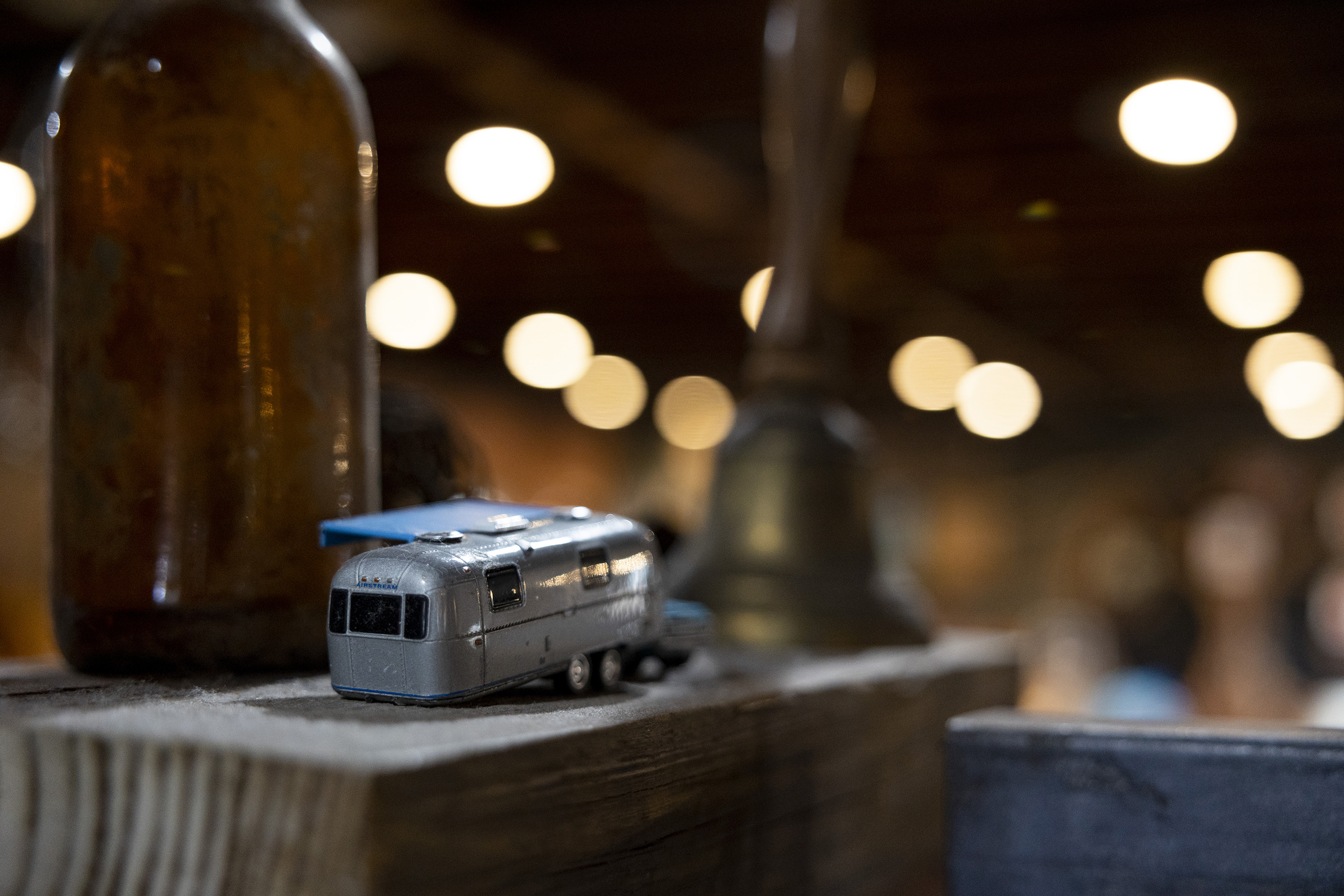 A closeup photo of a miniature silver Airstream trailer and an out-of-focus background. 