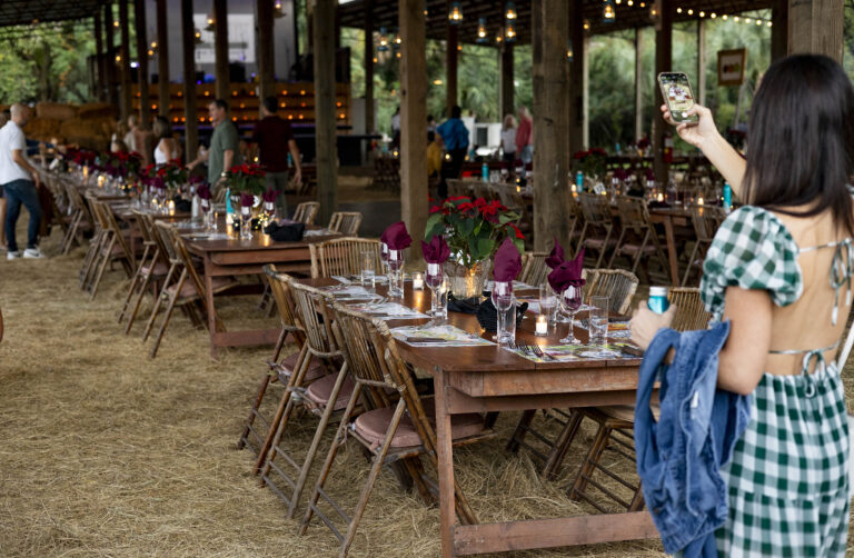 Swank Table event at Swank Specialty Produce in Loxahatchee. Women takes a photo of beautifully set tables.
