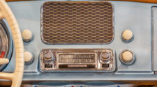 Road Trip playlist. Old chrome car radio with speaker inside a classic American car