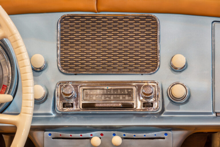 Road Trip playlist. Old chrome car radio with speaker inside a classic American car