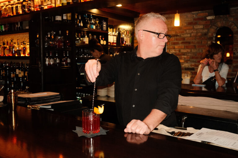Brett Hart, bartenders at Okeechobee Steakhouse, stirring a cocktail.