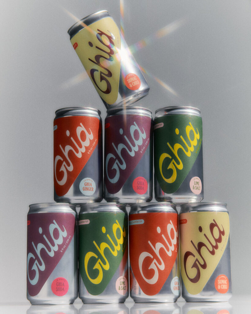 Cans of various Ghia adaptogen cocktail flavors stacked in a pyramid 