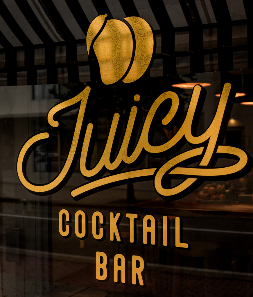 Gold sign painted on door for Juicy Cocktail Bar in West Palm Beach. 