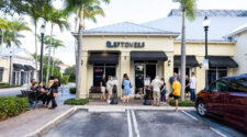 A line of people forms out of the front door and onto the sidewalk of Leftovers Cafe in Jupiter. Leftover's is dog friendly in the outside seating section.