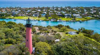 Drone photo of the Jupiter Lighthouse and Inlet. The ocean is visible in the distance.