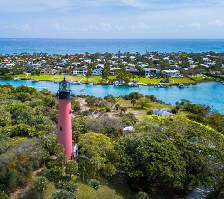 Drone photo of the Jupiter Lighthouse and Inlet. The ocean is visible in the distance.