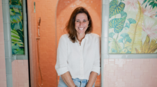 Lani Goodrich, creative ceramicist standing in front of her coral, handmade tiles.