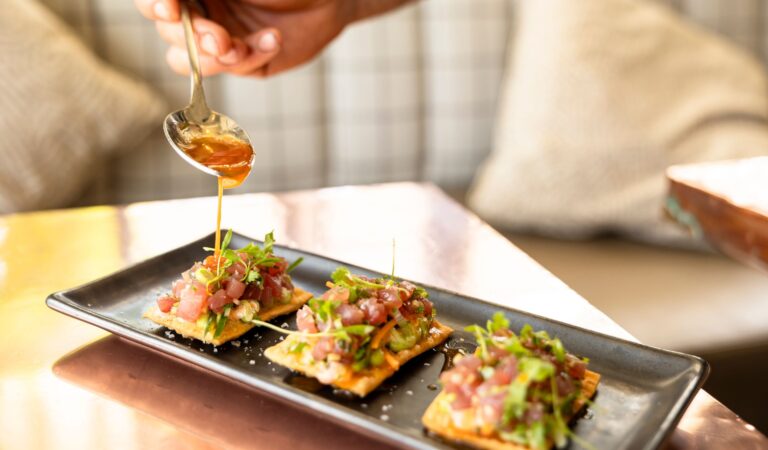 Close-up of Chef Clay Conley plating dishes at Buccan in Palm Beach.