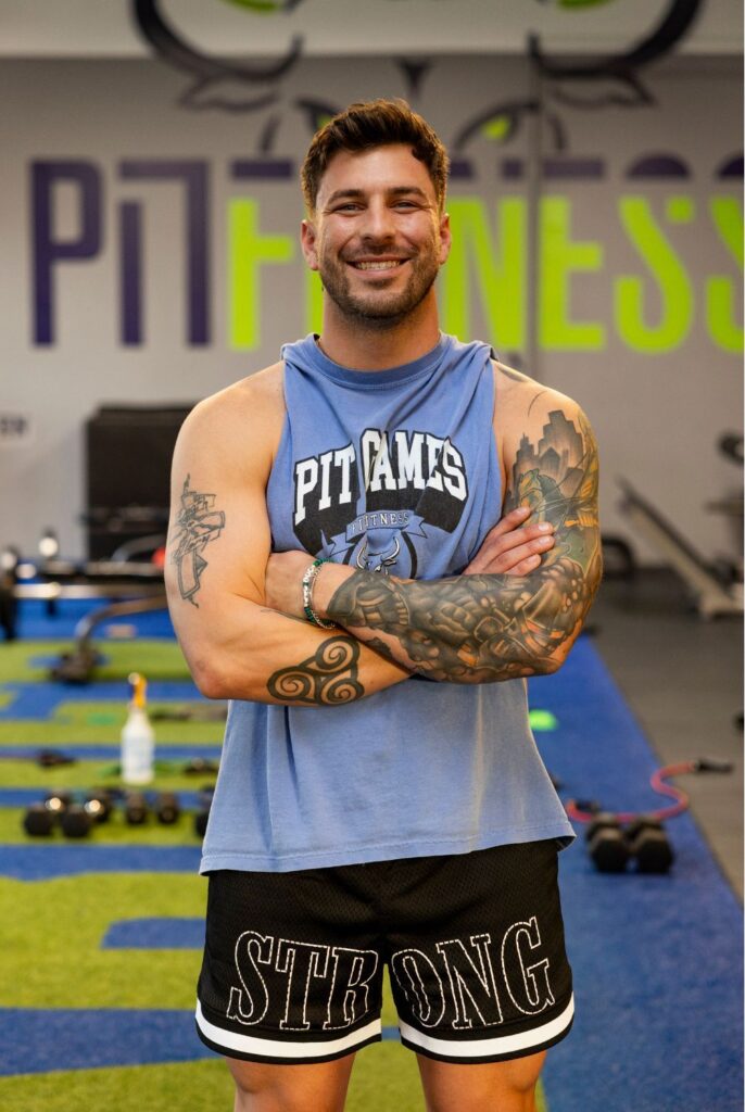 Trainer at PIT Fitness, Brian Pease, stood smiling with crossed arms.