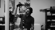 60 Minutes Photo owner Hunter Hutchings holds up an unrolled strip of film.