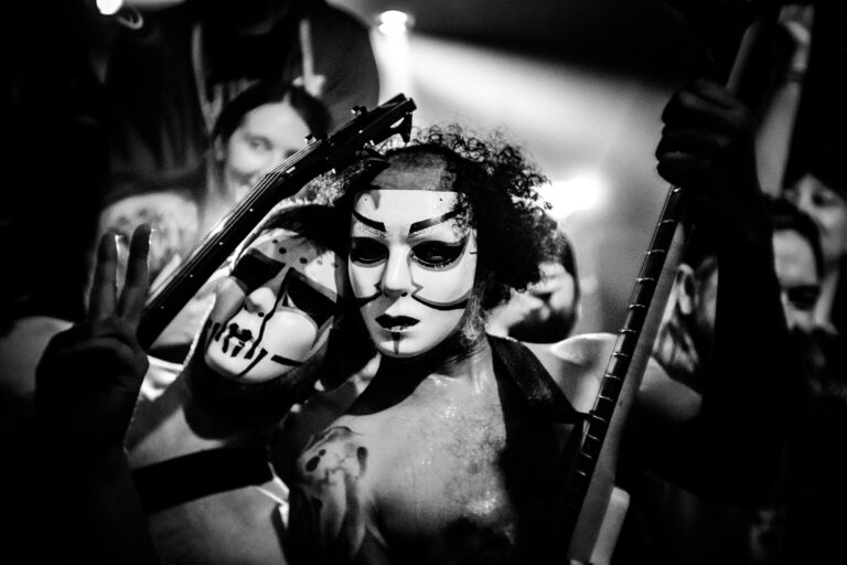 Band members of Daikaiju in masks in black and white inside Respectable Street bar in West Palm Beach.
