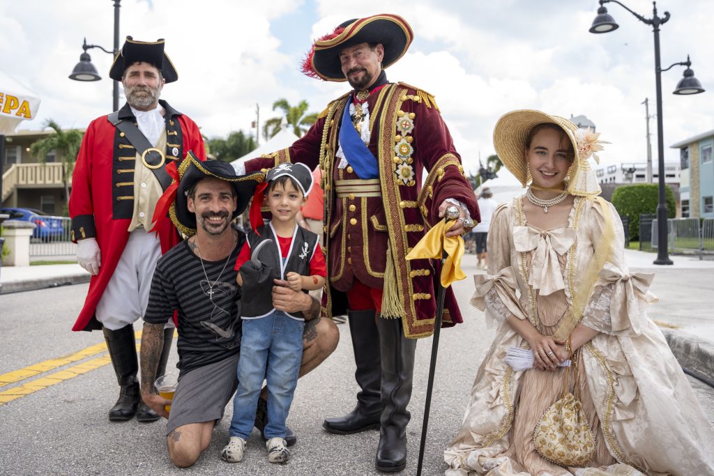 A father and son pose with pirate characters at Pirate Fest 2024 In Boynton Beach.