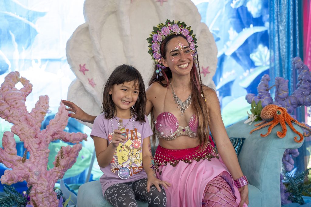 A little girl poses for a picture with a mermaid at Pirate Fest 2024 In Boynton Beach.