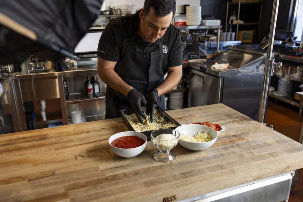 Chef Koby Wexler putting together a pizza.